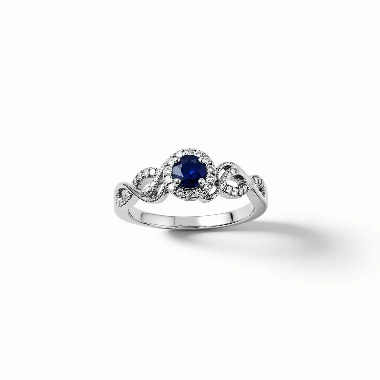 This vine engagement ring features a beautifully intricate design with a metal band that elegantly intertwines in a vine-like pattern. At its center, a deep blue sapphire gemstone is set in a classic prong setting, cut in a round shape, which draws the eye with its rich color and brilliance. Surrounding the central gemstone is a halo of small, sparkling diamonds, enhancing the sapphire's allure. The band, likely crafted from white gold or platinum, complements the cool tones of the stones, adding a sophisticated finish to the overall design. The seamless flow of the vine pattern and the secure prong setting harmoniously blend to create a stunning piece.