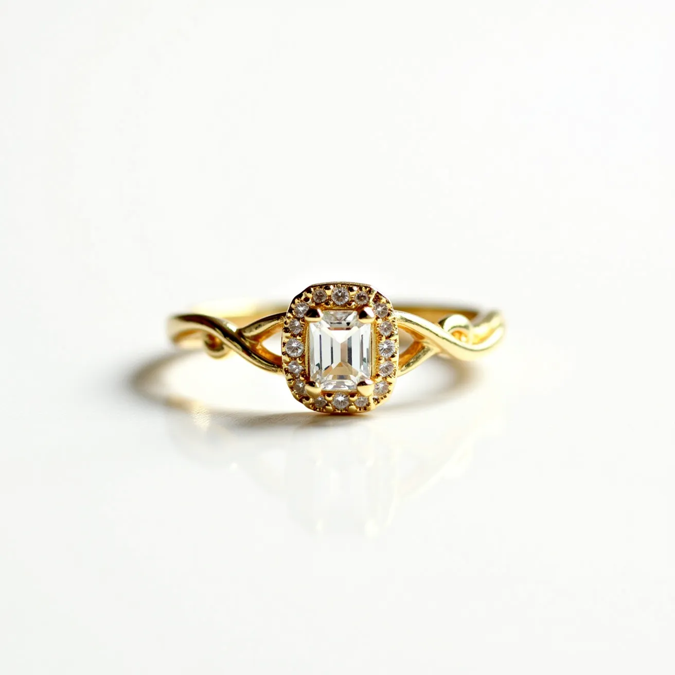 This vine engagement ring features a delicate and intertwined band crafted from what appears to be yellow gold, adding a warm and classic touch. The centerpiece is an emerald-cut diamond, elegantly emphasizing the geometric and linear facets of the stone, which is securely held in place by a halo setting. Surrounding the central diamond is a circle of smaller round diamonds, enhancing its brilliance and creating a shimmering effect. The flowing vine design of the band adds an organic and romantic aesthetic, with the graceful curves flowing seamlessly into the halo of diamonds, making it a stunning choice for an engagement ring.