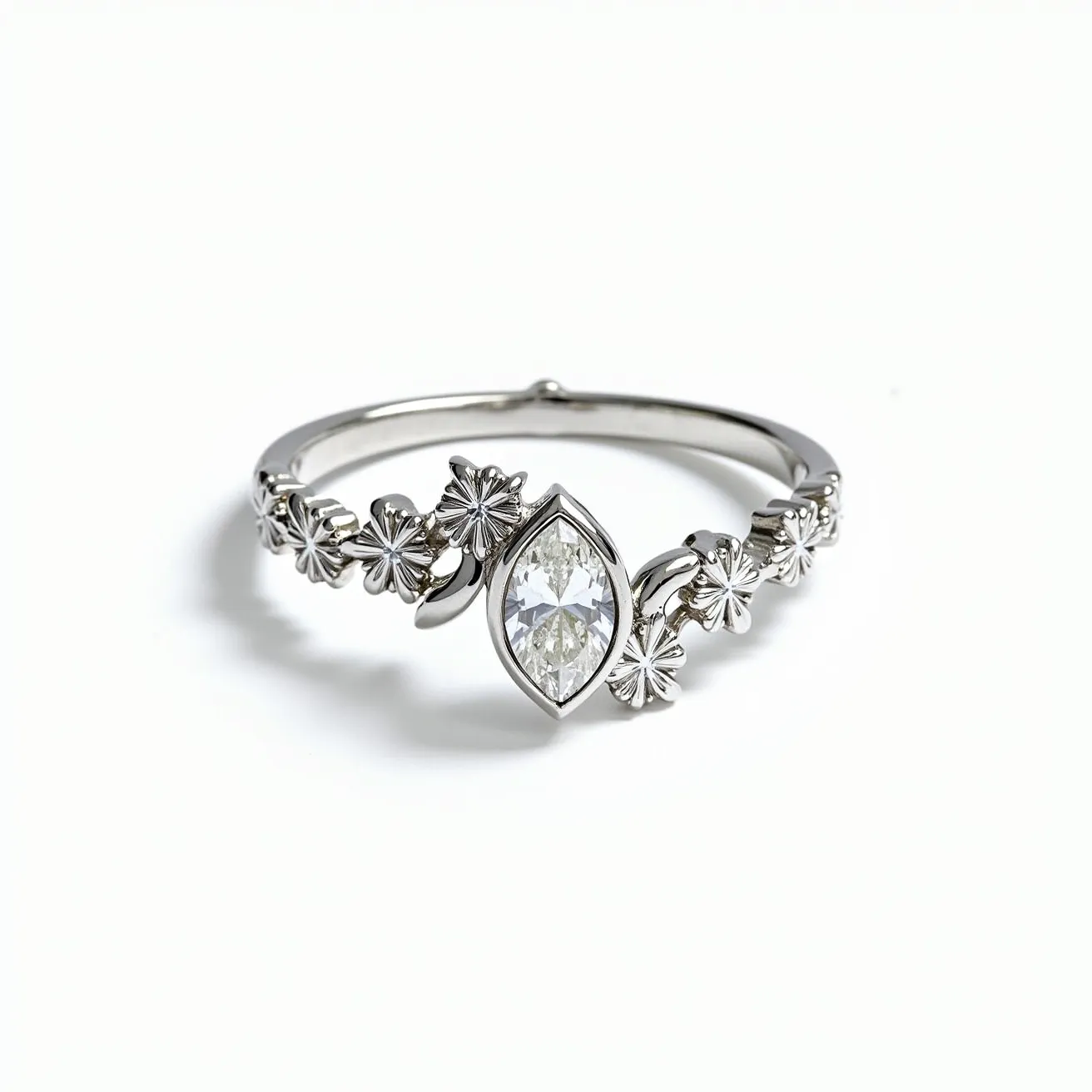 This vine ring features a delicate band crafted from polished metal, likely silver or white gold, adorned with intricately detailed floral elements that resemble a vine wrapping around the finger. At its center, the ring is set with a marquise-cut gem, possibly a diamond or clear gemstone, securely held in a bezel setting that enhances its shape and sparkle. The combination of the vine design and the central gem creates an elegant and nature-inspired piece, with no visible clasp or attachment interrupting its smooth and continuous design.