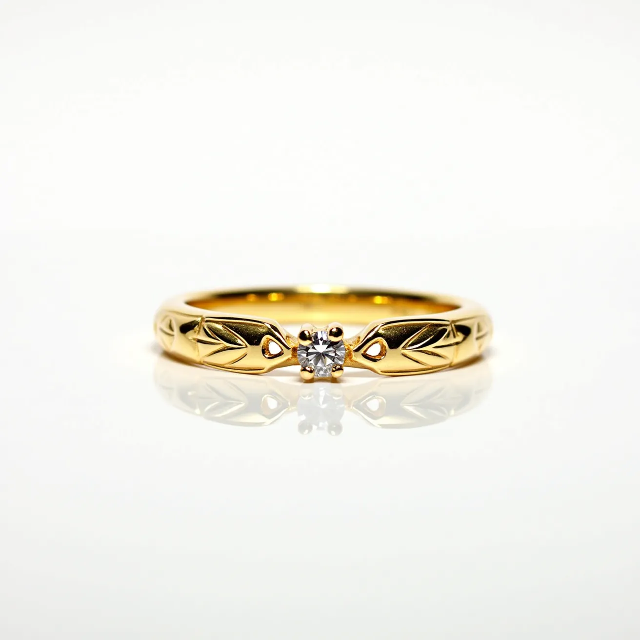 This wedding band is crafted from gold and features intricate leaf engraving along its surface. Centrally set is a sparkling round-cut diamond, securely held in a four-prong setting, which adds a touch of elegance and brilliance to the design. The smooth, polished finish of the gold complements the gleaming gemstone, creating a harmonious and timeless look. The absence of any clasps or additional attachments emphasizes the band’s simplicity and focus on the central diamond.