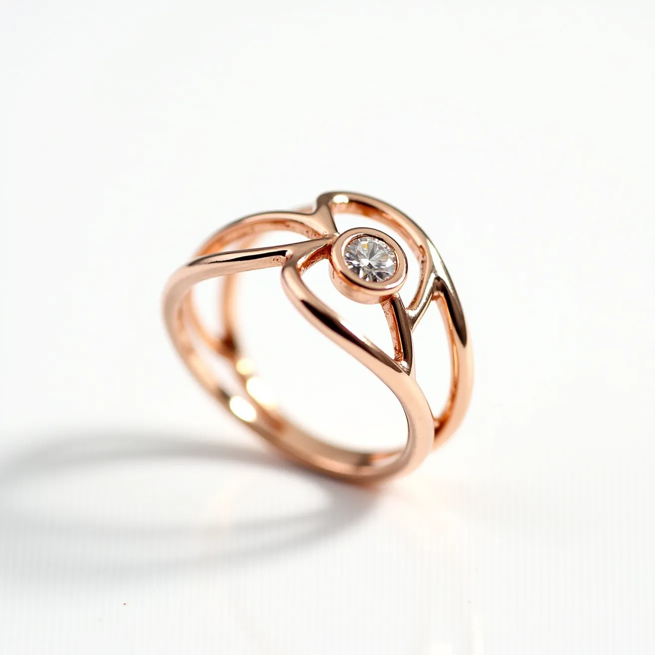 This wedding ring features a sophisticated design crafted from rose gold, characterized by a split shank band that elegantly intertwines, creating a visually striking and modern aesthetic. At its center, the ring showcases a brilliant round-cut diamond, securely held in a bezel setting that enhances the stone's brilliance while offering a smooth, contemporary look. The combination of the rose gold and the sparkling diamond creates a harmonious balance of warmth and elegance, making it an exquisite symbol of love.