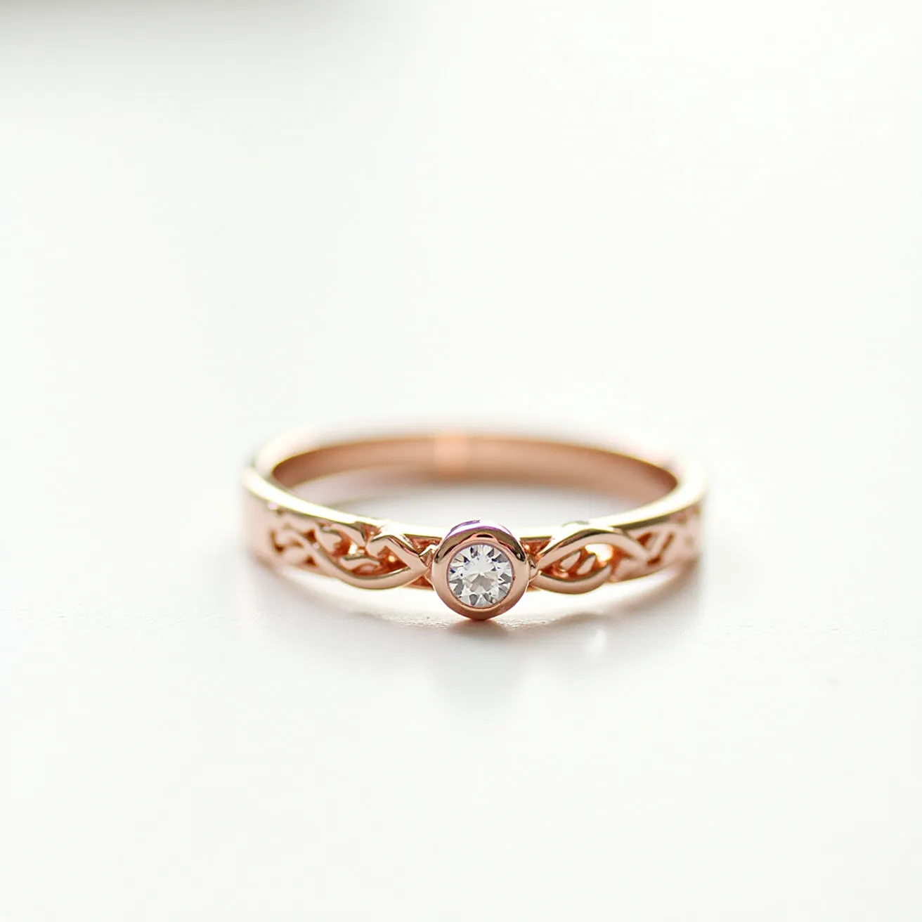 This wedding ring features a delicate design crafted from rose gold, characterized by an intricate braided band. The centerpiece is a round diamond, expertly cut and set in a bezel setting that offers both security and elegance. The rose gold metal enhances the brilliance of the diamond, creating a harmonious contrast that adds to the ring's refined aesthetic.