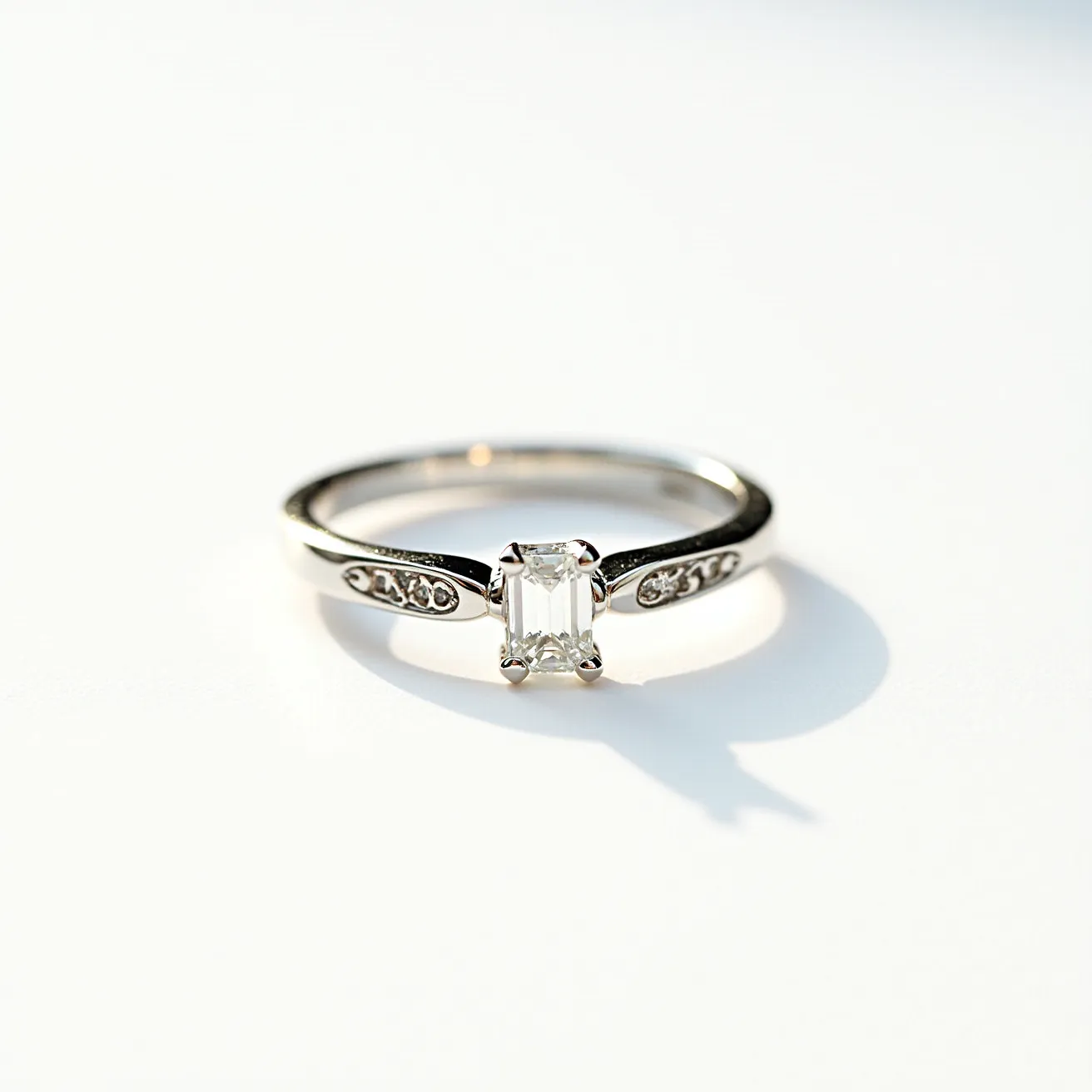 This wedding ring features a classic and elegant design with a glossy band made of what appears to be white gold or platinum, offering a sleek and modern aesthetic. At its center, the ring showcases an emerald-cut diamond in a four-prong setting, emphasizing the stone's clarity and geometric lines. Additionally, the band is adorned with smaller round diamonds, embedded in a channel setting on either side of the central stone, adding extra sparkle and sophistication. The overall design is both timeless and contemporary, highlighting the intricate craftsmanship and attention to detail without the need for any clasps or attachments.