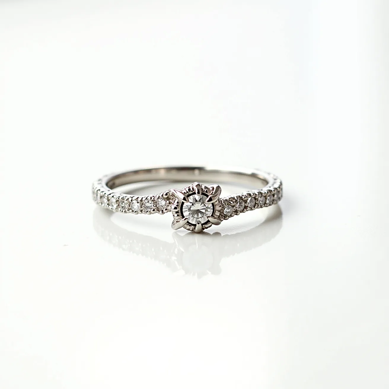 This wedding ring features a delicate band made of what appears to be white gold or platinum, intricately adorned with small, round diamonds in a pave setting that extend along the band. The centerpiece is a brilliant-cut diamond held securely by a unique floral or star-shaped prong setting, which enhances the stone's sparkle and prominence. The combination of the central diamond's cut with the detailed setting creates an elegant and timeless aesthetic, with the side stones adding additional brilliance and texture to the overall design.