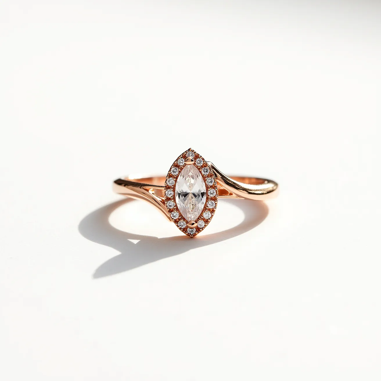 This unique wedding ring features a delicate rose gold band that elegantly supports a marquise-cut diamond as the central gemstone. The diamond is beautifully set in a halo of smaller round diamonds, enhancing its brilliance and creating a stunning focal point. The marquise cut, with its elongated shape and pointed ends, adds a touch of sophistication and flair. The ring showcases classic craftsmanship with a secure setting that allows the stones to reflect light from all angles, creating a timeless piece of jewelry.