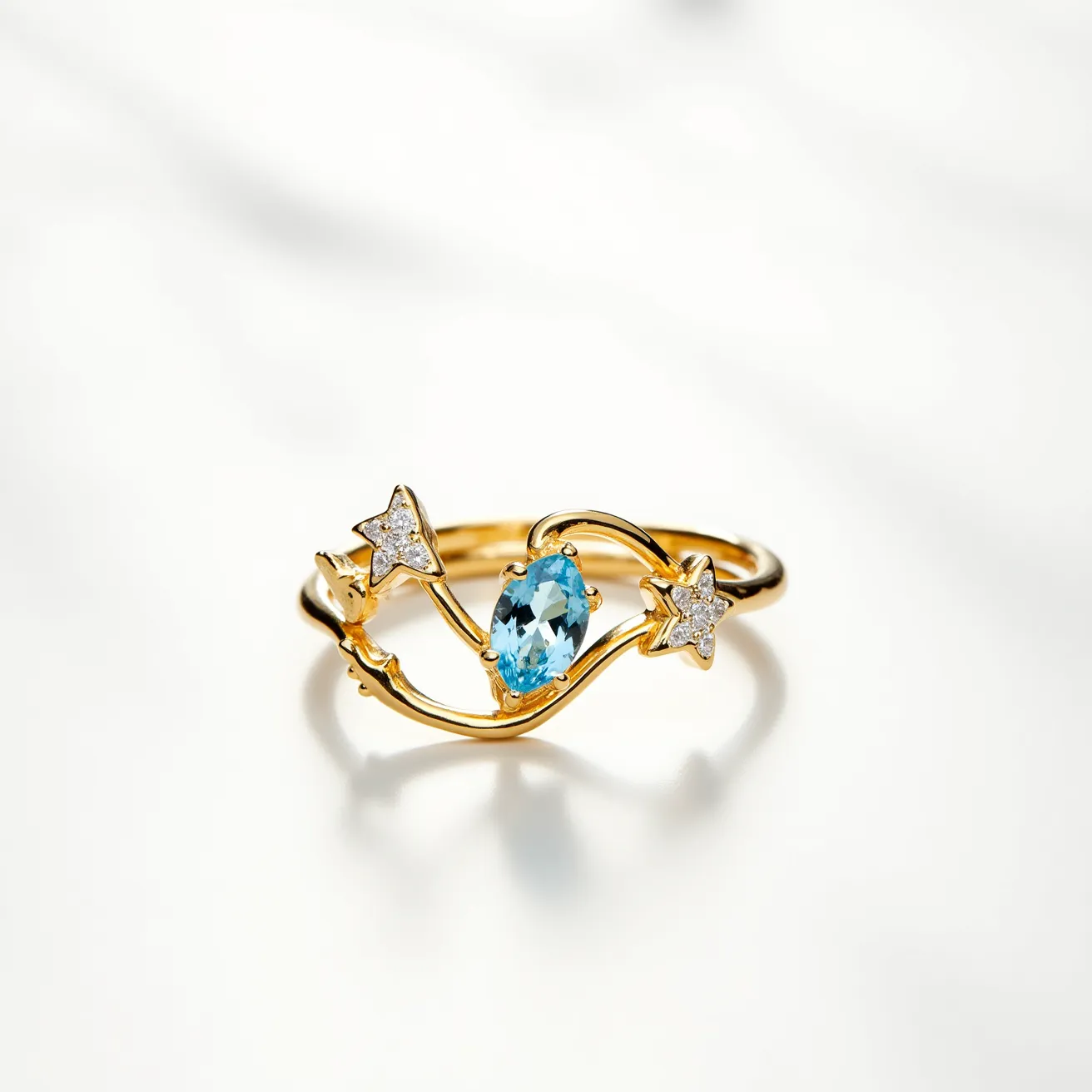 This wrap ring features an elegant design crafted from gold, showcasing intricate curves that give it a delicate appearance. At the center, a marquise-cut blue gemstone is prominently set, adding a vibrant touch to the piece. On either side of the central stone, two star-shaped embellishments are adorned with small, round-cut clear stones, likely diamonds, set in a prong setting to enhance their sparkle. The interplay of the blue and clear stones against the gold band results in a harmonious and captivating aesthetic.