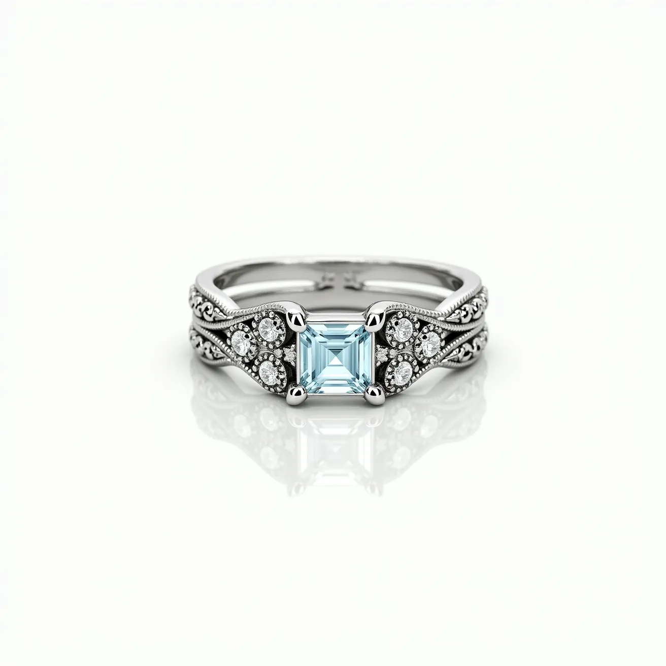 This wrap ring features a central square-cut stone with light blue hues, meticulously set in a four-prong claw setting. The band is crafted from a silver or white gold material, providing a sleek and elegant backdrop that complements the gemstones. Surrounding the central stone, there are smaller round-cut diamonds clustered in bezel settings, adding a delicate sparkle to the intricate design. The band itself showcases ornate detailing, enhancing the ring's vintage-inspired aesthetic and creating a sense of sophistication and timeless beauty.