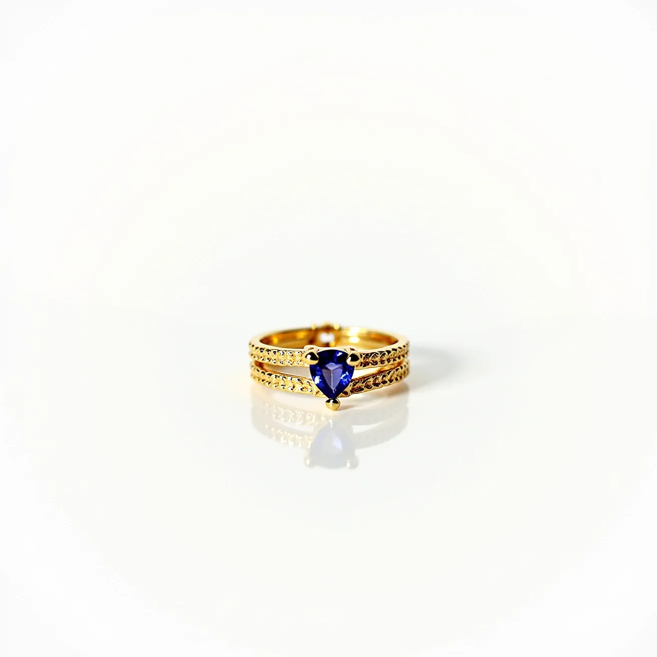 This wrap ring elegantly showcases a deep blue, heart-shaped gemstone nestled in a classic prong setting at its center. Crafted from a lustrous gold material, the band features intricate detailing along its length that enhances its luxurious appearance. The prongs securely hold the central gem in place, displaying its facets and vibrant color. The ring's wrap design adds a graceful continuity and sophistication, making it a standout piece.